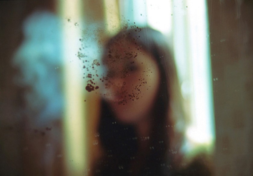 Woman behind dirty window. From the 'Bees' project by Zhe Chen.