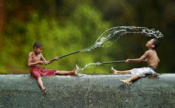 Indonesian boys having water fight